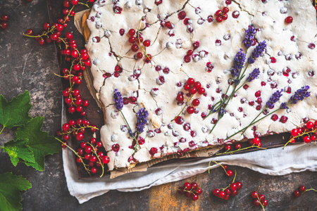 Whole currant cake with crispy meringue on top and fresh fruits as decoration, top viewの写真素材