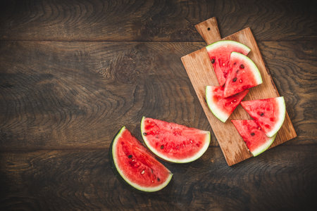 Sliced fresh watermelon on rustic wooden background, top view, copy spaceの写真素材