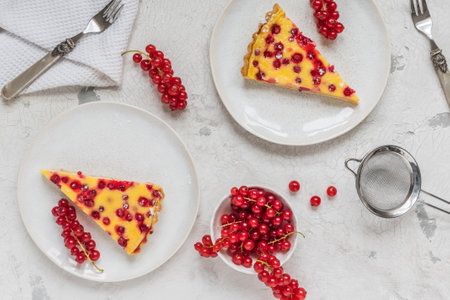 Two pieces of homemade red currant pie on white background, decorated with fresh red currants, top viewの写真素材
