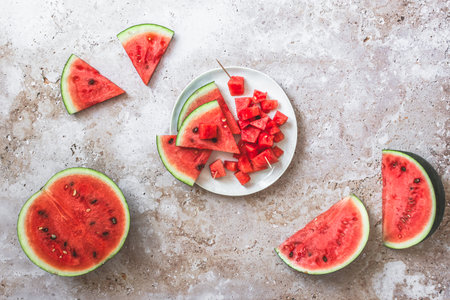 Sliced and chunky fresh watermelon on beige structured background, top view, copy spaceの写真素材