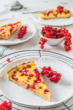 Piece of homemade red currant pie on white background, decorated with fresh red currants, verticalの写真素材