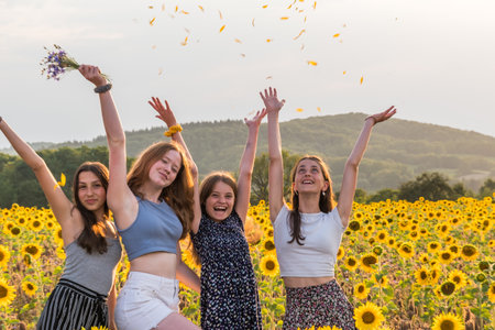 Teenage girls having fun in a sunflower field on a late summer afternoonの写真素材