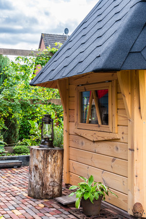 Part of a garden shed with outdoor decoration and paved footpath, verticalの写真素材