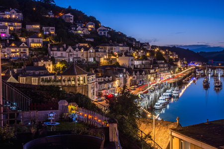 Looe, Cornwall, UK - August 14, 2023: Harbor and town at blue hour with lights reflected in the waterのeditorial素材