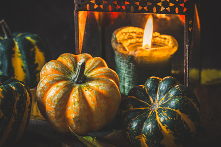 Pumpkins and rusty lantern with candle for autumn decoration, dark wooden backgroundの写真素材