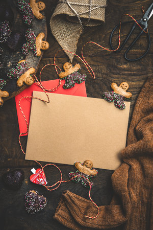 Scene for gifts in Advent with cookies, gift ribbon and card for text on dark wooden back ground, Christmas concept. copy space, top view, verticalの写真素材