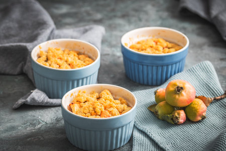 Apple crumble in small blue molds on a rustic gray tableの写真素材