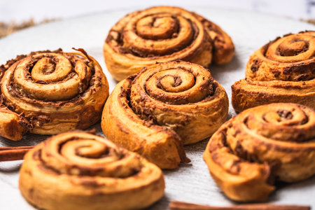 Closeup of homemade cinnamon rolls on white plate on white marble backgroundの写真素材
