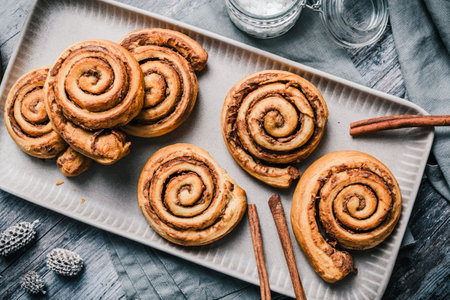 Homemade cinnamon rolls on a gray earthenware tray on gray background, top viewの写真素材