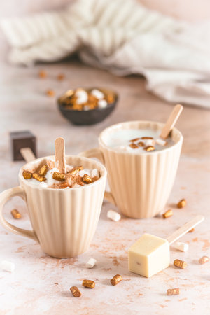 Two cups with hot chocolate dipping sticks and marshmallowsの写真素材