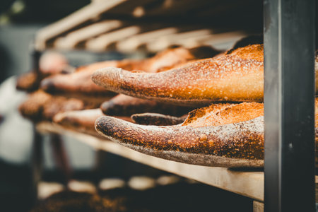 Freshly baked baguettes on a shelf in a bakeryの写真素材