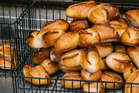 Freshly baked rolls in a black metal basketの写真素材