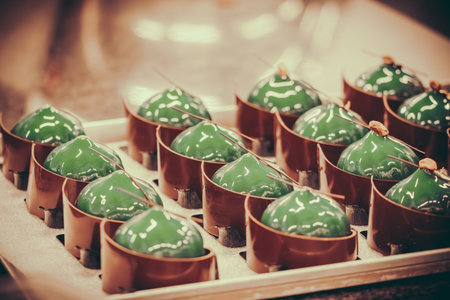 Green glazed tartlets with chocolate. Tartlets prepared to be finished by a professional pastry...