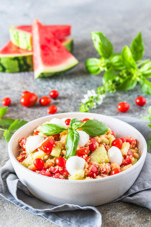 Couscous salad with tomatoes, cucumber, water melon, mozzarella, basil. Fresh summer salad.の写真素材