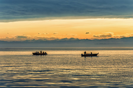 View of lake with two fishing boats on an early winter morning, before sunrise