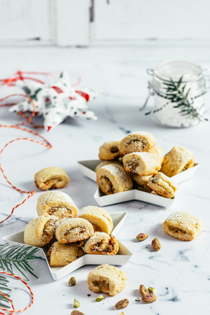 Shortcrust pastry cookies with pistachio filling, Christmas baking, pistachio rolls on white background, verticalの写真素材