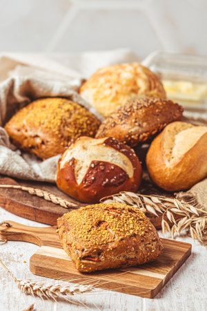 Delicious variety of German buns and bread rolls on white wooden background, verticalの写真素材