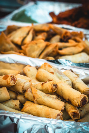 Fried Thai mini spring rolls, variety of Asian street food dishes in the backgroundの写真素材