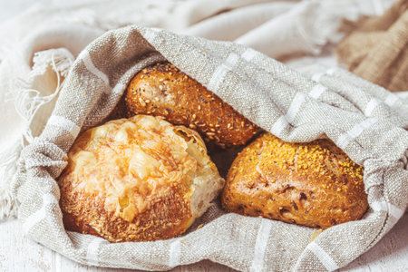 Three bread rolls in a linen bag, preparation for breakfastの写真素材