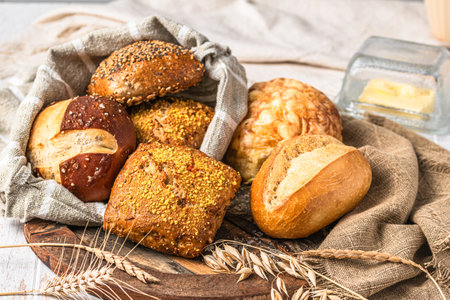 Delicious variety of German buns and bread rolls on white wooden backgroundの写真素材
