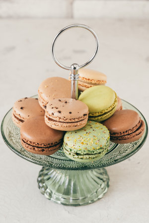 Colorful french macarons on a glass etagere. Pastries, desserts and sweets. Vertical stock photo.の写真素材