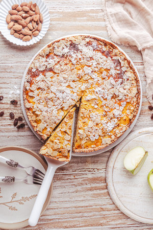 Homemade apple pie with roasted almonds on white wooden background, top viewの写真素材