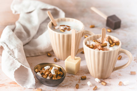 Two cups with hot chocolate dipping sticks and marshmallowsの写真素材