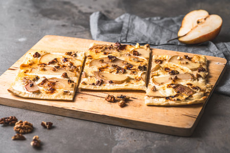 Tarte flambee with pear, Gorgonzola cheese, honey and walnuts on a gray background