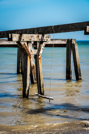 Old Quern pier, wooden sea bridge, near Neukirchen on the Baltic Sea in northern Germany. Vertical.