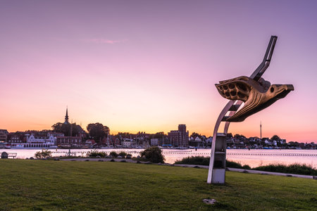 Kappeln, Germany - June 12, 2025: Sculpture Albatros, the figurehead of the sailing training ship Gorch Fock, at the Schlei bridge (Schleibruecke). City of Kappeln in the background. Copy space.の写真素材