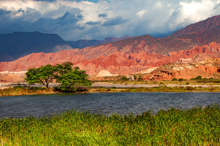 Colorful mountain landscape with chiaroscuro and a lagoon in the foreground.の写真素材