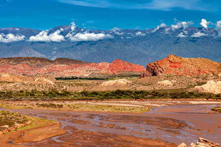 Landscape with a low-flow river with sandstone formations and mountains in the background.の写真素材