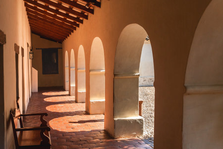 Colonial style gallery illuminated by the sun and with the shadow of a person.の写真素材