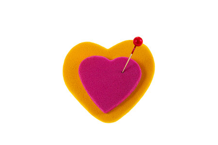 Two hearts of different colors joined by a pin as a concept of union and commitment.の写真素材