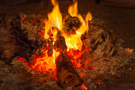 Fire in a bonfire that has burned the wood and generated embers. Before a celebration, a fire is prepared with wood so that its embers can be used in the barbecue.の写真素材