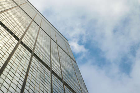Mirror Skyscraper and Cloudy Sky Bright Backgroundの写真素材