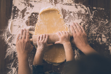 Mother and son rolling out cookie dough.の写真素材