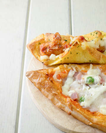pizza ham and sausage bread background on the white wooden floorの写真素材