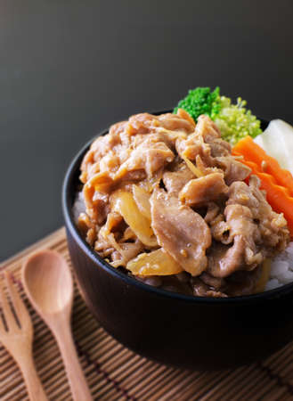 pork teriyaki with rice and vegetable on black bowlの写真素材