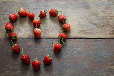 strawberry in heart shape on the wood tableの写真素材