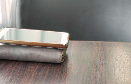mobile put on money bag on the wood tableの写真素材