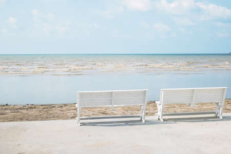 two white wooden chairs beside beach, vintage filter