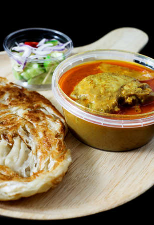 red curry chicken serve with roti and sour sauce on black backgroundの写真素材