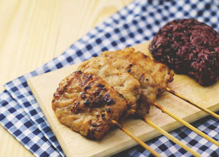 thai roasted pork and black sticky rice on wood table
