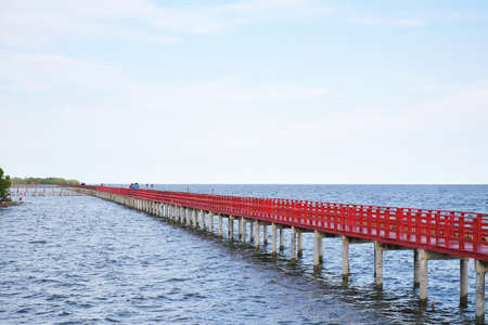 long red bridge beside water pierの写真素材