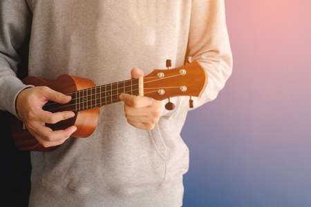 a man is playing guitar with blue color backgroundの写真素材