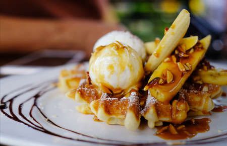 homemade waffles with sliced banana and caramel sauceの写真素材