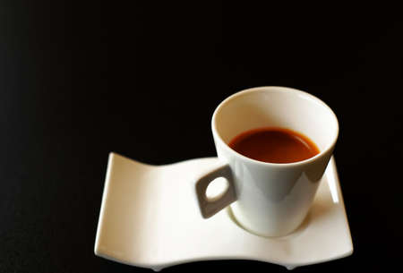 hot espresso in white cup on black background