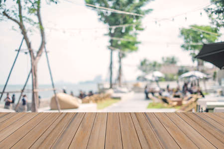 Wooden board table on blurry beach shop backgroundの写真素材