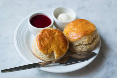 two scone with strawberry jam and cream cheese sauce
